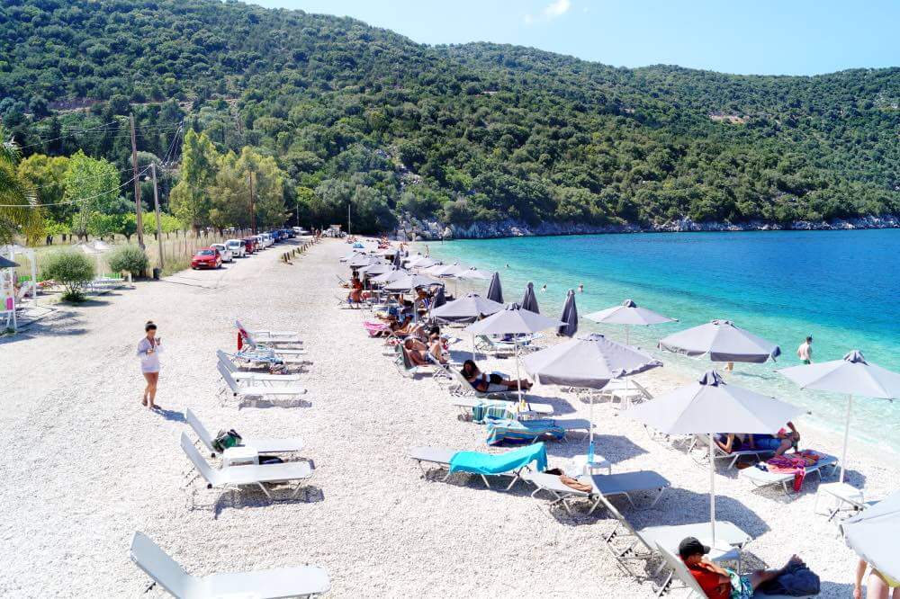 Sun beds with umbrellas on the beach of Antisamos, Kefalonia Photo: pebble Antisamos