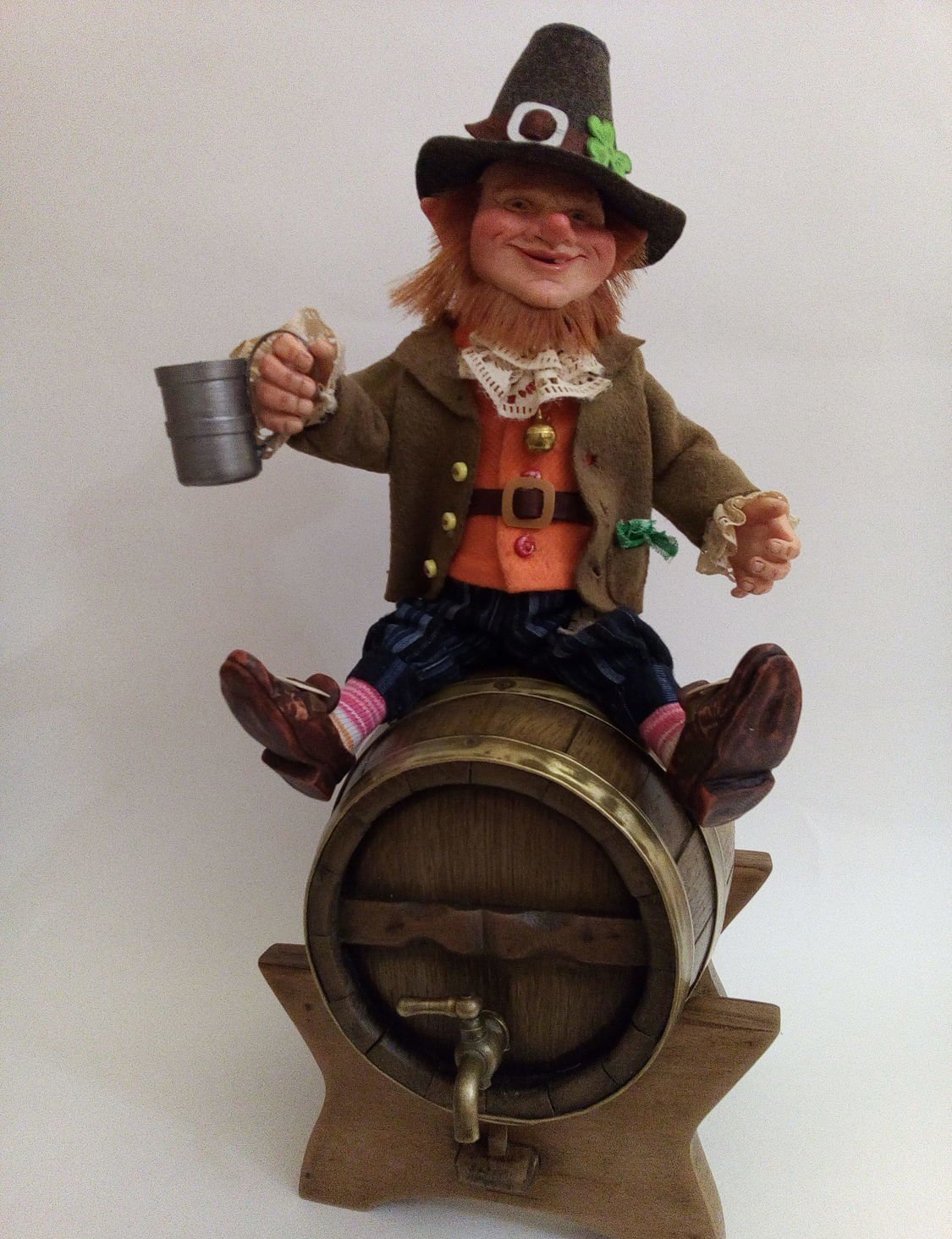 A statue of a leprechaun sitting on a barrel Leprechaun Figurine