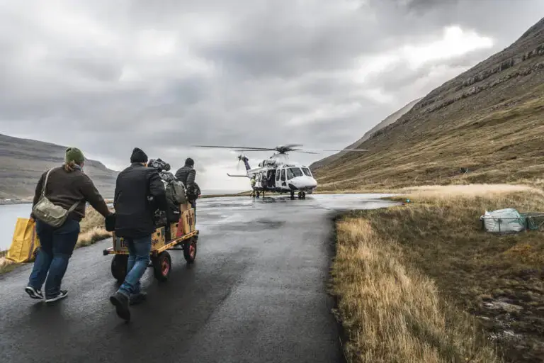 The photo shows people walking towards a helicopter in the Faroe Islands Helicopter in the Faroe Islands